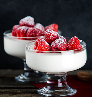 Indulgent Vanilla Yogurt Mousse made with Astro Yogurt topped with fresh raspberries served in decorative glass dessert bowls