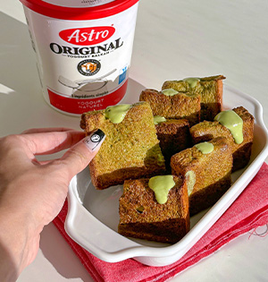 Pocket Matcha French Toast prepared with Astro Yogurt sitting in a serving dish with an Astro Plain 6% Yogurt tub in the background.
